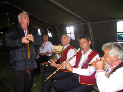 Five men singing and playing Macedonian instruments