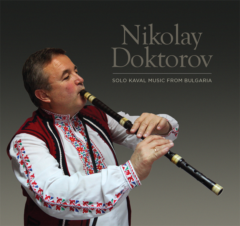 Image of Nikolay Doktorov playing the kaval while dressed in a traditional Bulgarian shirt and vest